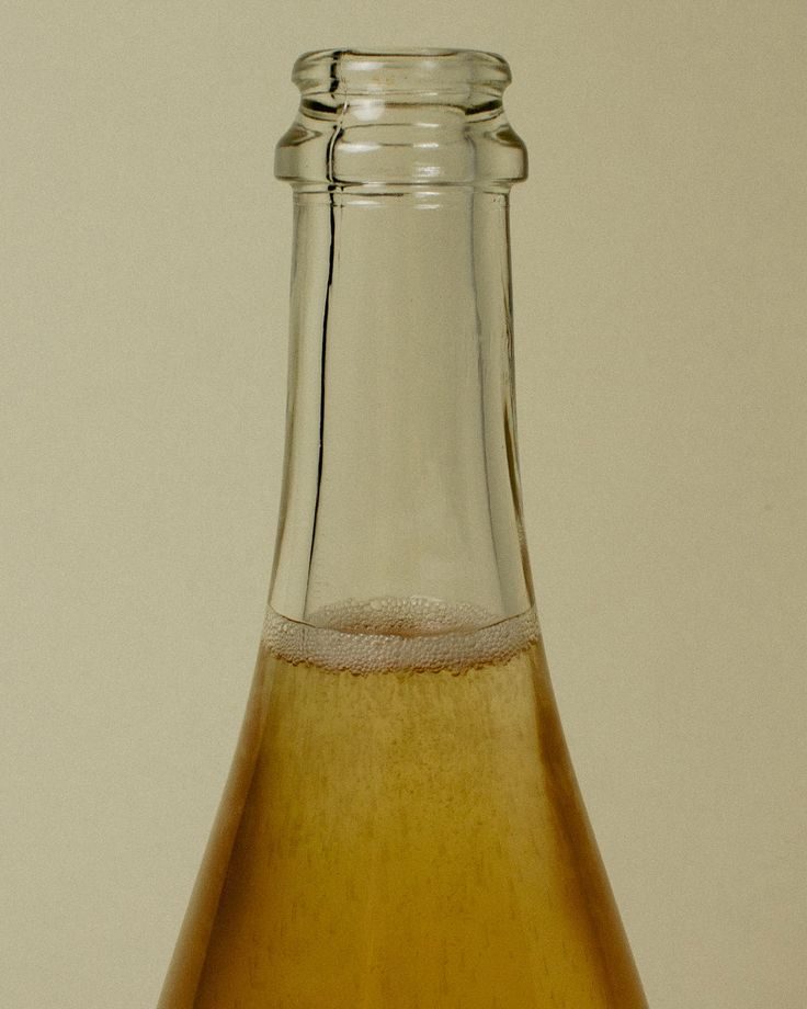 The neck of an Astra bottle, fine bubbles sitting at the shoulder.